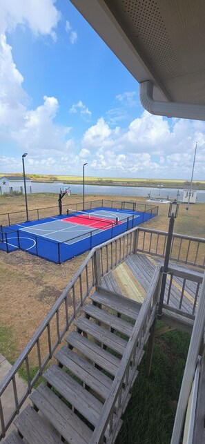 A basketball court with a wooden deck and a view of a lake.