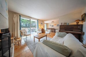Un saló amb un sofà, una taula de centre i un piano.