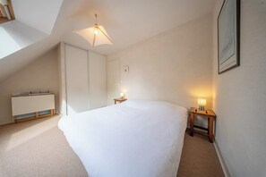 A bedroom with a large bed, a wardrobe, bedside tables with lamps, and a ceiling light fixture. - Coin de paradis - Grande maison pour 14 pers (Saint-Philibert)