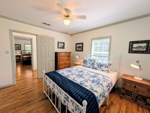 A bedroom with a bed, dresser, bedside lamps, and a ceiling fan. - The Hilltop Farmhouse (Mena)