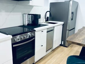 A modern kitchen with a stove, oven, coffee maker, sink, and refrigerator. - Private Bsmt Apt W/Separate Entry- 1 Min to Subway (Oak Park)