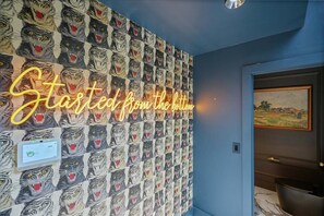 A wall with a pattern of tiger faces and a neon sign that reads 'Started from the bottom.' - The SB Gallery House Unapologetically Different (Raleigh)