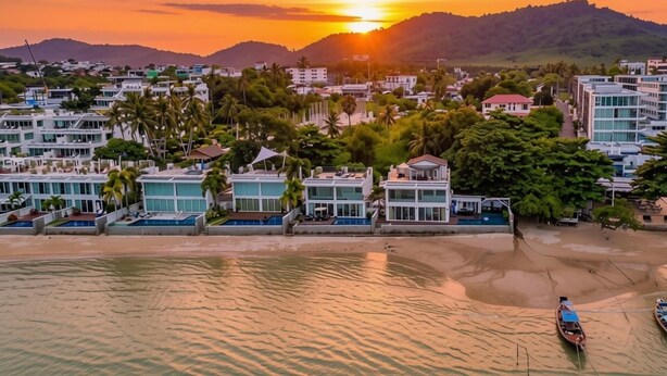 A coastal resort with modern buildings, a beach, and a sunset. - Absolute Oceanfront Tara Villa 4 Bed Selina Resort (rawai)