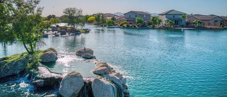 A residential area with a body of water, rocks, and houses.