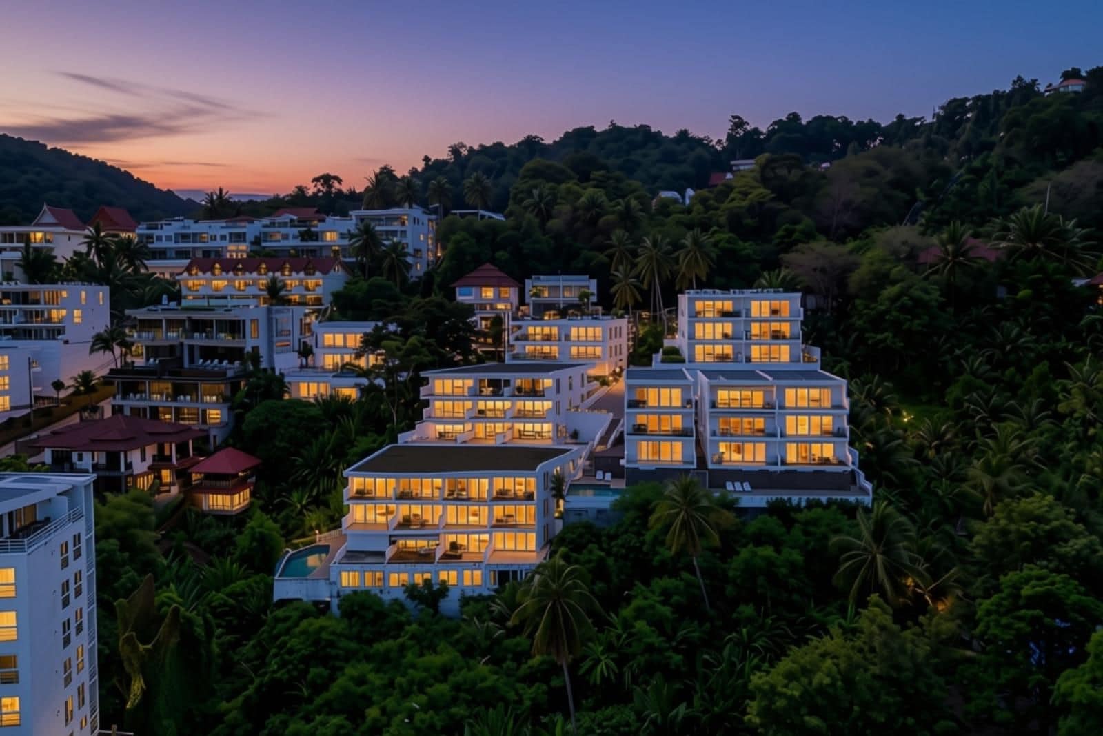 Un hotel de varios pisos con balcones, rodeado de densa vegetación tropical.