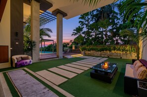 A modern outdoor lounge area with artificial grass, a fire pit, and lounge chairs. - At The Tree Sea View 1BR Walk To Rawai Beach (Rawai)