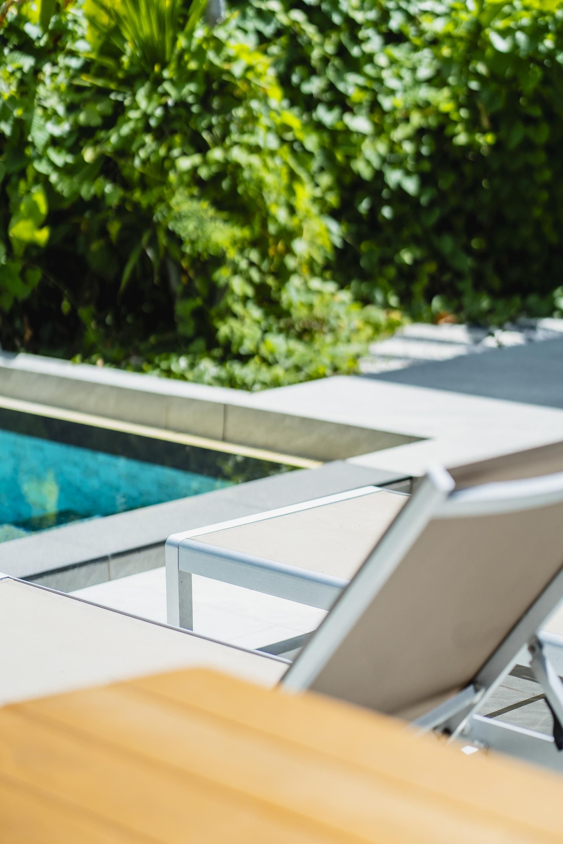 A poolside area with lounge chairs and a swimming pool.