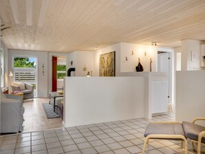 A modern interior with a kitchen area, a dining space, and a living area with a sofa and chairs. - "Helemine" - 800m from the sea by Interhome (Blokhus)