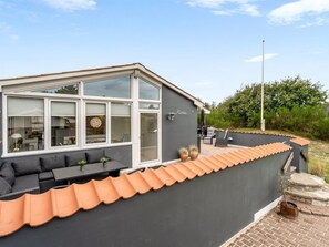A modern house with a patio area, a dining table, and outdoor seating. - "Helemine" - 800m from the sea by Interhome (Blokhus)
