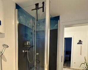 A glass-enclosed shower with a handheld showerhead and a wall-mounted faucet. - Guest Rooms Eifelgluck in Pelm (Pelm)