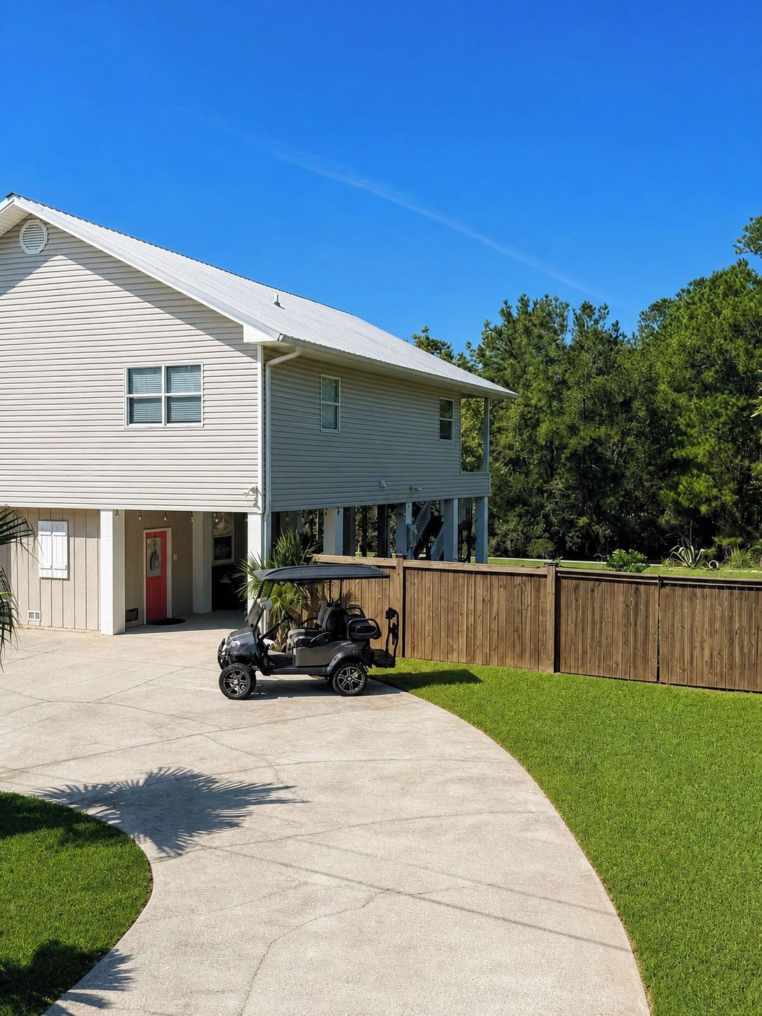 A two-story house with a covered porch and a golf cart parked in the driveway.