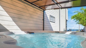 A hot tub area with a view of a building and a tree. - Palme Bayfront Estate | 4 Homes, Pool + Hot Tub (Bacliff)