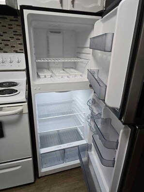 Una cucina con forno integrato e frigorifero dotato di numerosi ripiani e cassetti.