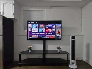 A flat-screen TV mounted on a wall with a black entertainment center below.