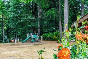 A playground with slides and climbing structures surrounded by trees. - Rural 2BR Dog Friendly - Dock - Deck - Firepit (Hoodsport)