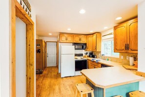 A kitchen with wooden cabinets, a white refrigerator, a stove, and a microwave. - Rural 2BR Dog Friendly - Dock - Deck - Firepit (Hoodsport)