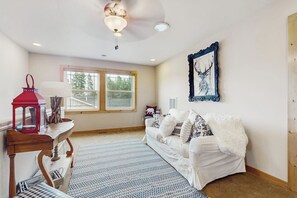 A cozy room with a white sofa, a red lantern, a patterned rug, and a framed artwork on the wall. - 2 BR Lakefront home with kayak and paddle boat (Cle Elum)
