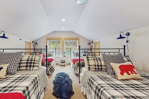 A room with two beds, a dog, and a window with a view of trees. - 2 BR Lakefront home with kayak and paddle boat (Cle Elum)