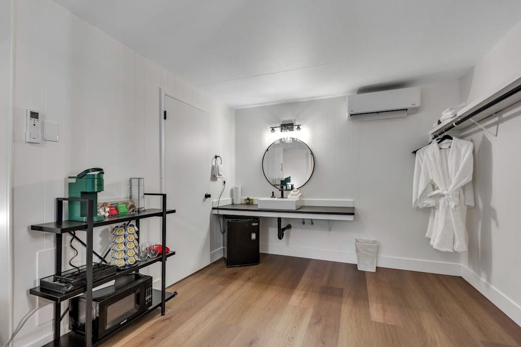 Een kleine badkamer met een wastafel, spiegel en handdoekhouder.