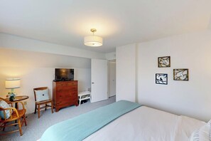 A bedroom with a bed, dresser, television, and artwork on the wall. - 2BR with amazing views, firepit (Bow)