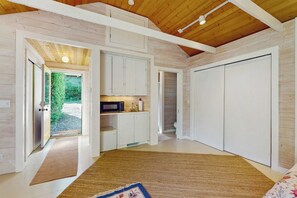 A room with a wooden ceiling, white cabinets, a bed, and a view of greenery outside. - 2 BR Waterfront home on Bainbridge Island (Bainbridge Island)
