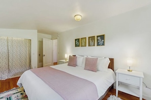 Ein Schlafzimmer mit einem Bett, Nachttischen und einer Tür.