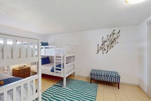 Een kamer met stapelbedden, een bankje en een decoratie aan de muur.