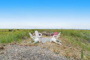 A beachside seating area with Adirondack chairs and a fire pit. - 2BR oceanfront house with beach access (Westport)