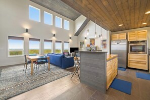 A modern kitchen with a large island, built-in appliances, and a view of the outdoors. - 2BR oceanfront house with beach access (Westport)