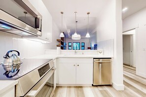 A modern kitchen with stainless steel appliances, white cabinetry, and pendant lighting. - 1BR dog-friendly condo with gas fireplace (Cle Elum)
