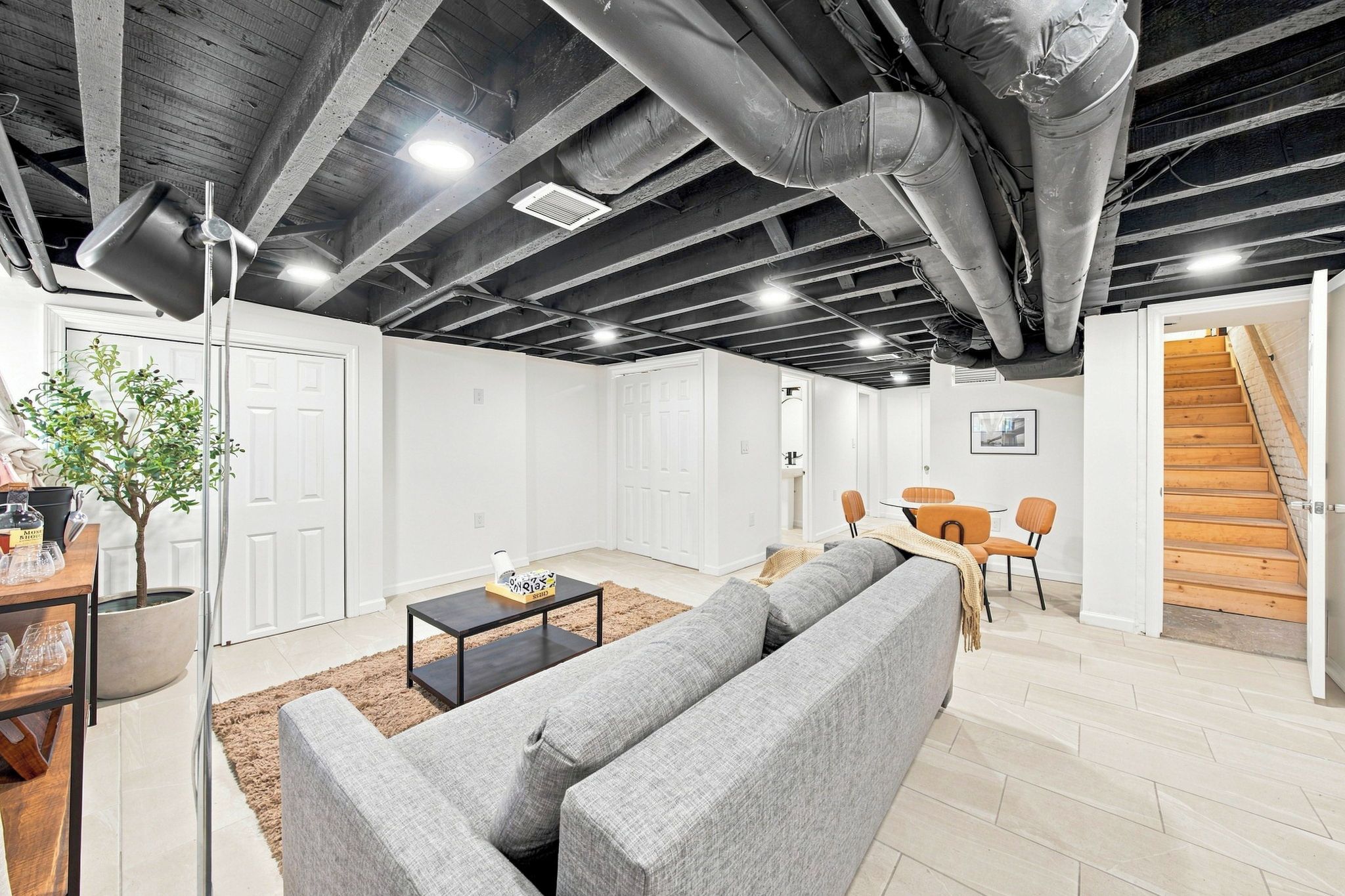 Ein modernes Interieur mit einer Eckcouch, einem Couchtisch und einem Essbereich mit Stühlen.