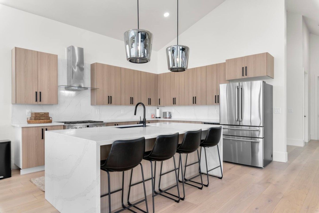 A modern kitchen with a central island, stainless steel appliances, and wooden cabinetry.