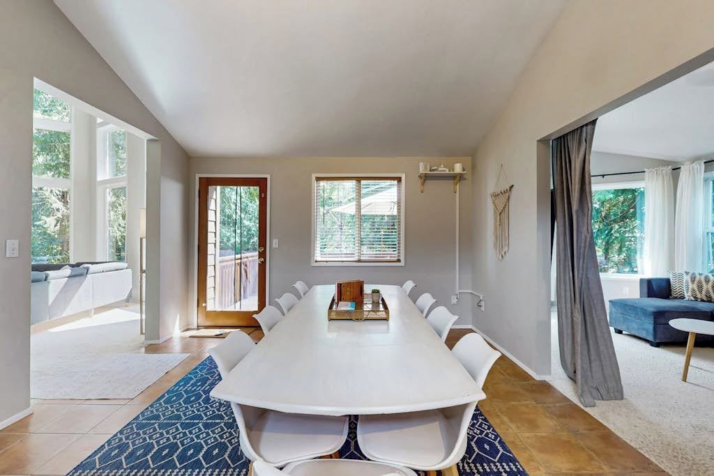 A spacious room with a large conference table, a sofa, and a view of the outdoors.