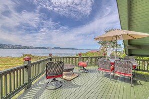 A deck with outdoor furniture and a view of the water. - 1BR A-frame oceanfront (Anacortes)