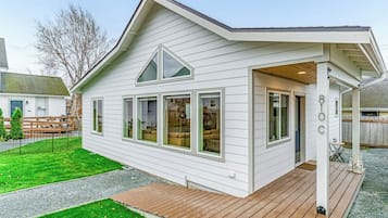A single-story house with a covered porch, a fenced yard, and a gravel driveway.