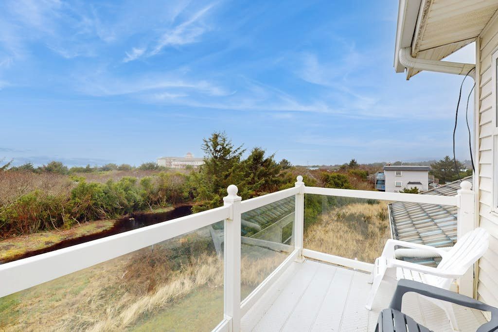 Ein Balkon mit Blick auf eine natürliche Landschaft und ein Gebäude in der Ferne.
