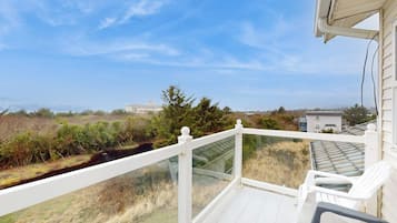 Ein Balkon mit Blick auf eine natürliche Landschaft und ein Gebäude in der Ferne.