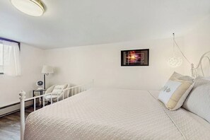 A bedroom with a bed, a bedside table, a chair, a lamp, and a framed picture on the wall. - 2BR Birch Bay: 3 Steps to Beach (Blaine)