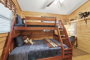 A bunk bed with a desk and chair, a window with blinds, and a ceiling fan. - Bear Essentials & Hot Tub (Blairsville)
