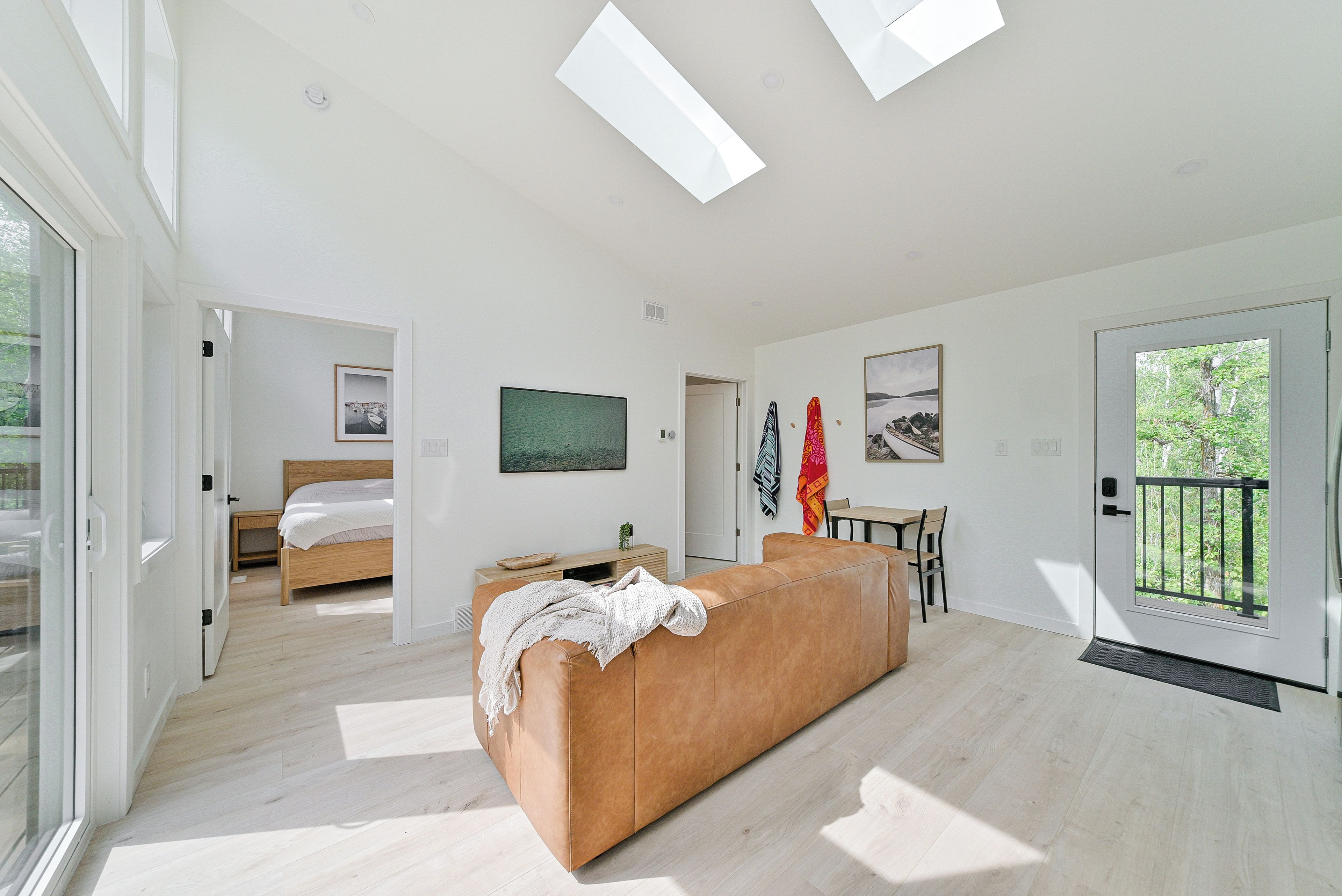 A modern living room with a sofa, a bed, and artwork on the walls.