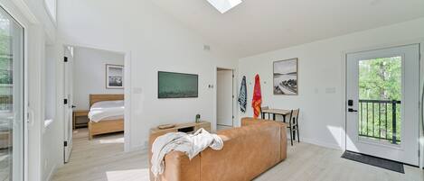 A modern living room with a sofa, a bed, and artwork on the walls.