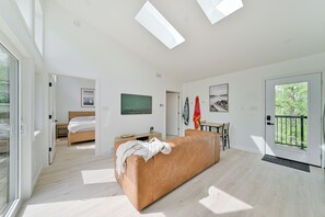 Ein modernes Wohnzimmer mit einer Couch, einem Bett und Kunstwerken an den Wänden.