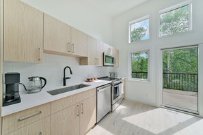 Una cocina moderna con microondas integrado, cafetera y lavavajillas.