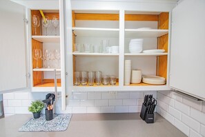 A kitchen with open cabinets displaying glassware, plates, and utensils. - Hot Tub-Pool Table-Near Beach and Wineries (Santa Maria)