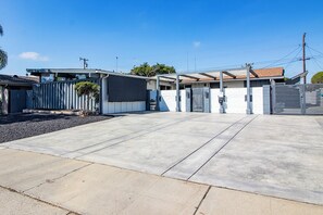 A residential area with a paved driveway, a gated entrance, and a row of single-story houses with attached garages. - Hot Tub-Pool Table-Near Beach and Wineries (Santa Maria)