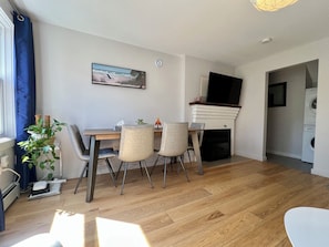 Una sala moderna con comedor, chimenea y vistas al exterior.