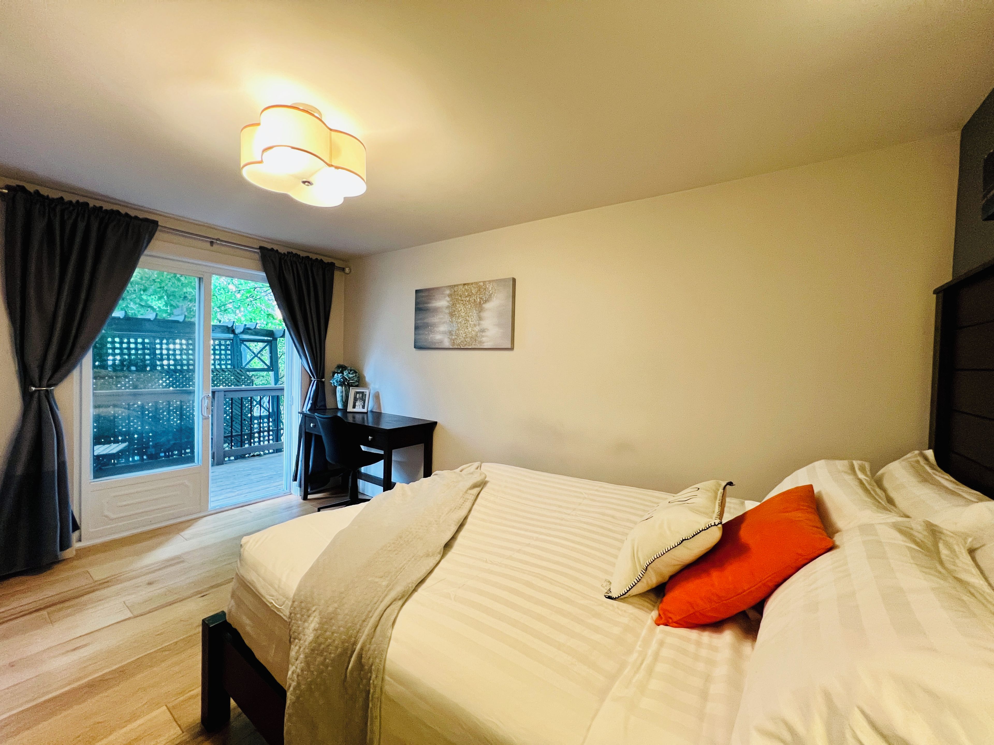 A bedroom with a bed, a desk, and a chair.