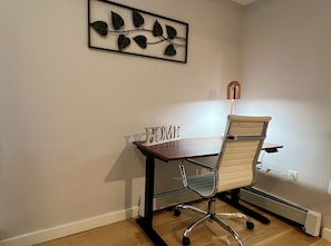 Un espacio de oficina moderno con un escritorio, una silla de oficina y un adorno de pared decorativo.