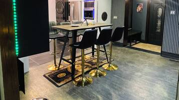 Ett modernt kök med matplats, inrett med ett runt bord och stolar, en inbyggd ugn och hängande lampor.