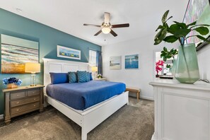 A bedroom with a bed, nightstands, a ceiling fan, and artwork on the walls. - 5BR - Gorgeous Pool Home - Close To Disney, Golf and Water Park (Davenport)